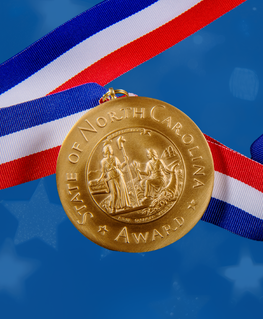 A gold award medal featuring the Great Seal of the State of North Carolina.